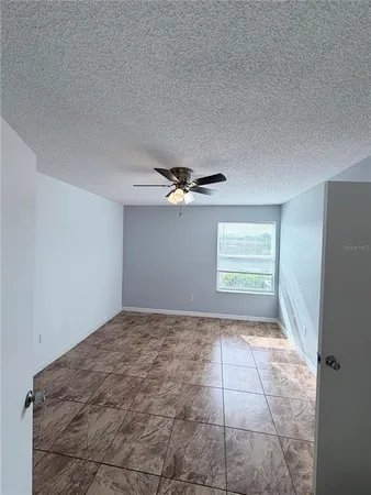a view of a livingroom with a chandelier fan and window