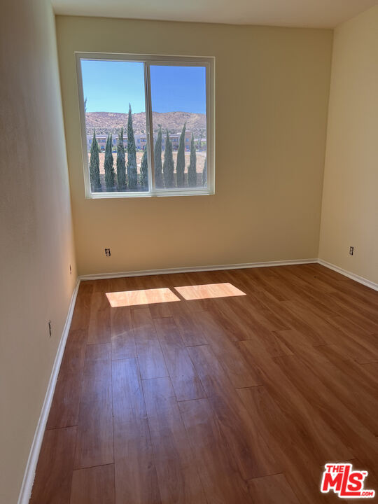 40247 Preston Road Palmdale, CA 93551 - Photo 12 of 15 a view of an empty room with wooden floor and a window