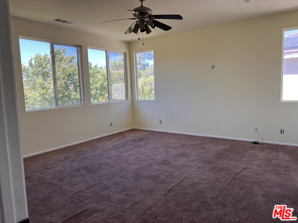 40247 Preston Road Palmdale, CA 93551 - Photo 8 of 15 an empty room with windows and chandelier fan