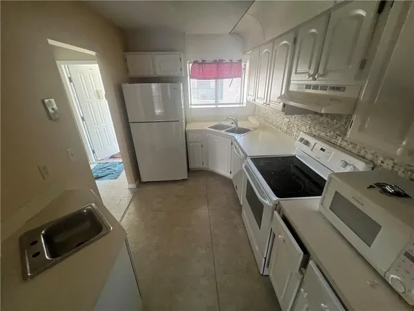 a kitchen with a refrigerator sink and stove