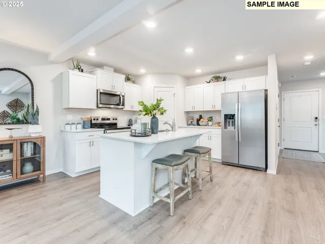 a kitchen with kitchen island a refrigerator a stove a microwave oven a sink with island and chairs