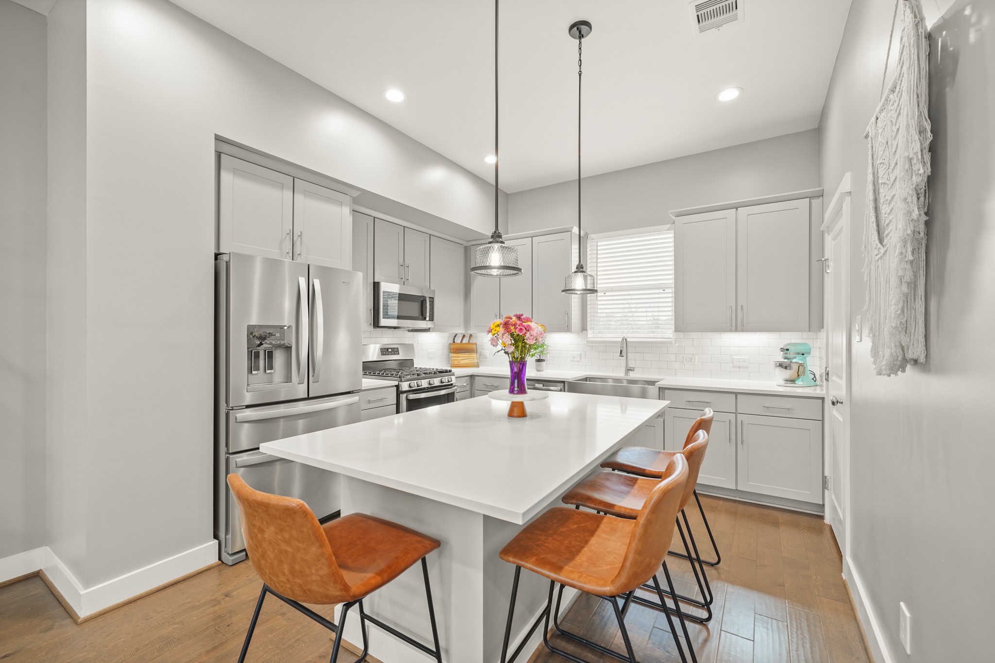 720 West Donovan Street Houston, TX 77091 - Photo 12 of 42 Surrounded by 42" Shaker-style cabinets capped with crown moulding, under cabinet lighting & soft close cabinets & drawers, this gorgeous kitchen includes quartz counter tops with a subway tiled back splash and hardwood floors.
