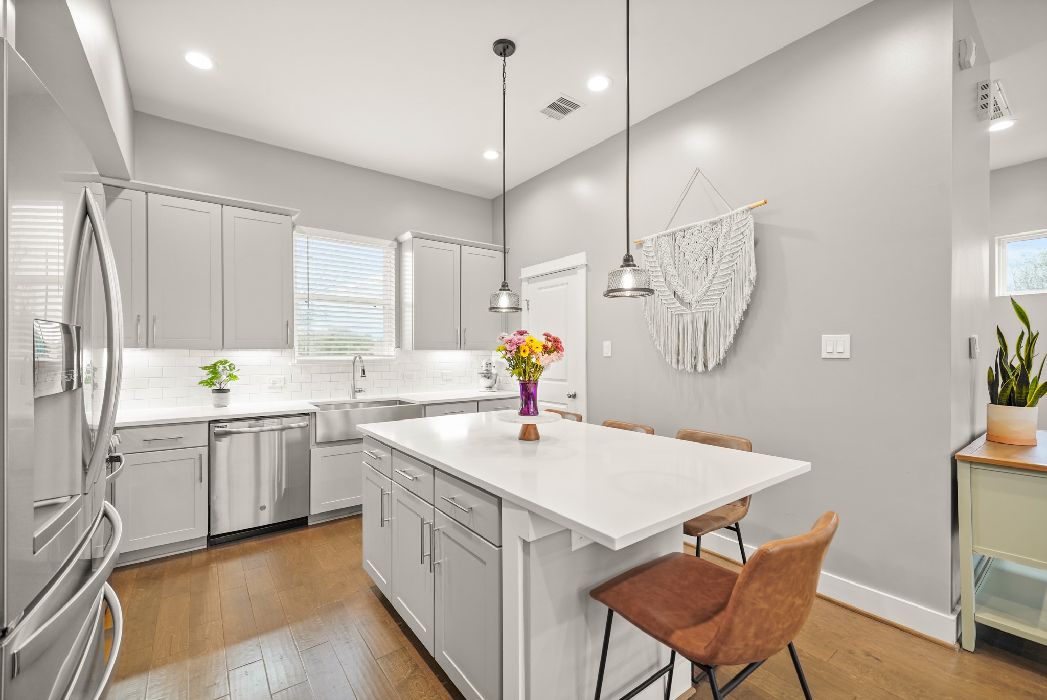720 West Donovan Street Houston, TX 77091 - Photo 13 of 42 Bright & cheery, the kitchen includes a quartz surfaced island with breakfast bar seating illuminated by pendant lighting. To the right is a walk-in pantry.