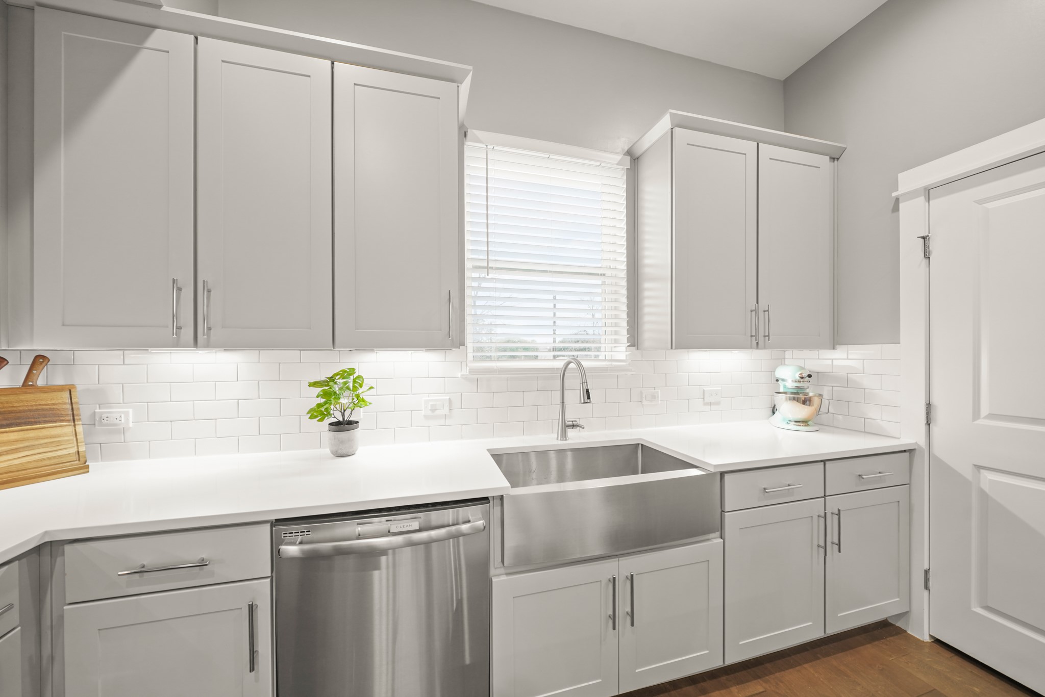 720 West Donovan Street Houston, TX 77091 - Photo 14 of 42 A window with blinds sits just above the stainless steel apron front sink with a satin nickel finish accompanied by plenty of counter space on each side.