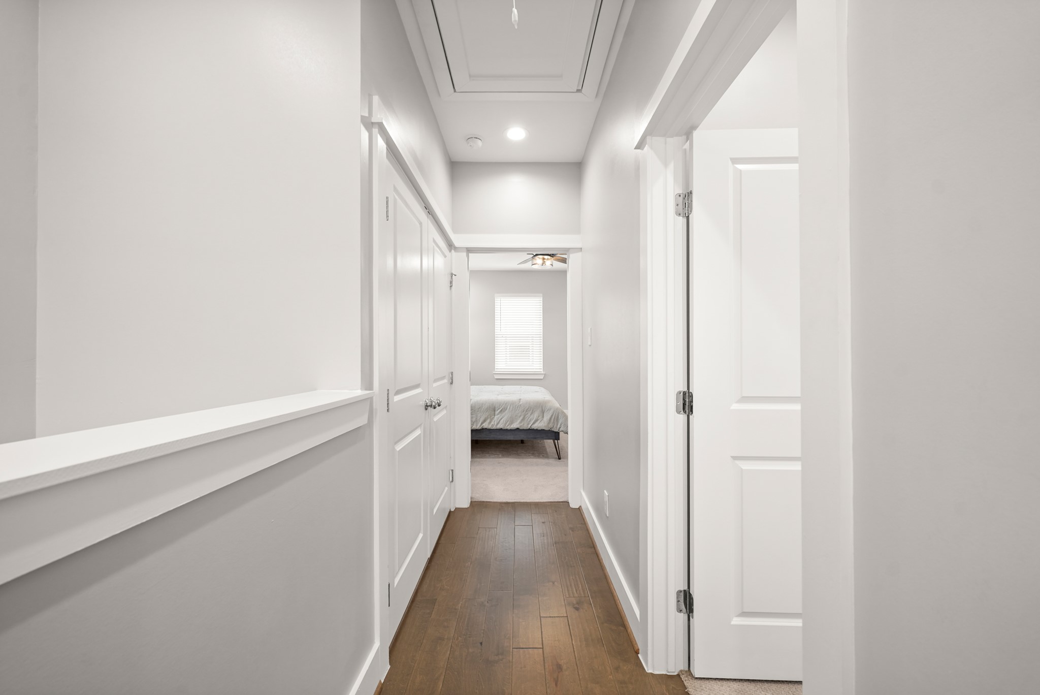 720 West Donovan Street Houston, TX 77091 - Photo 19 of 42 The third floor hallway offers hardwood floors leading to the primary bedroom. Conveniently located, the utility room is accessible by the double door on the left and a second bedroom to the right.