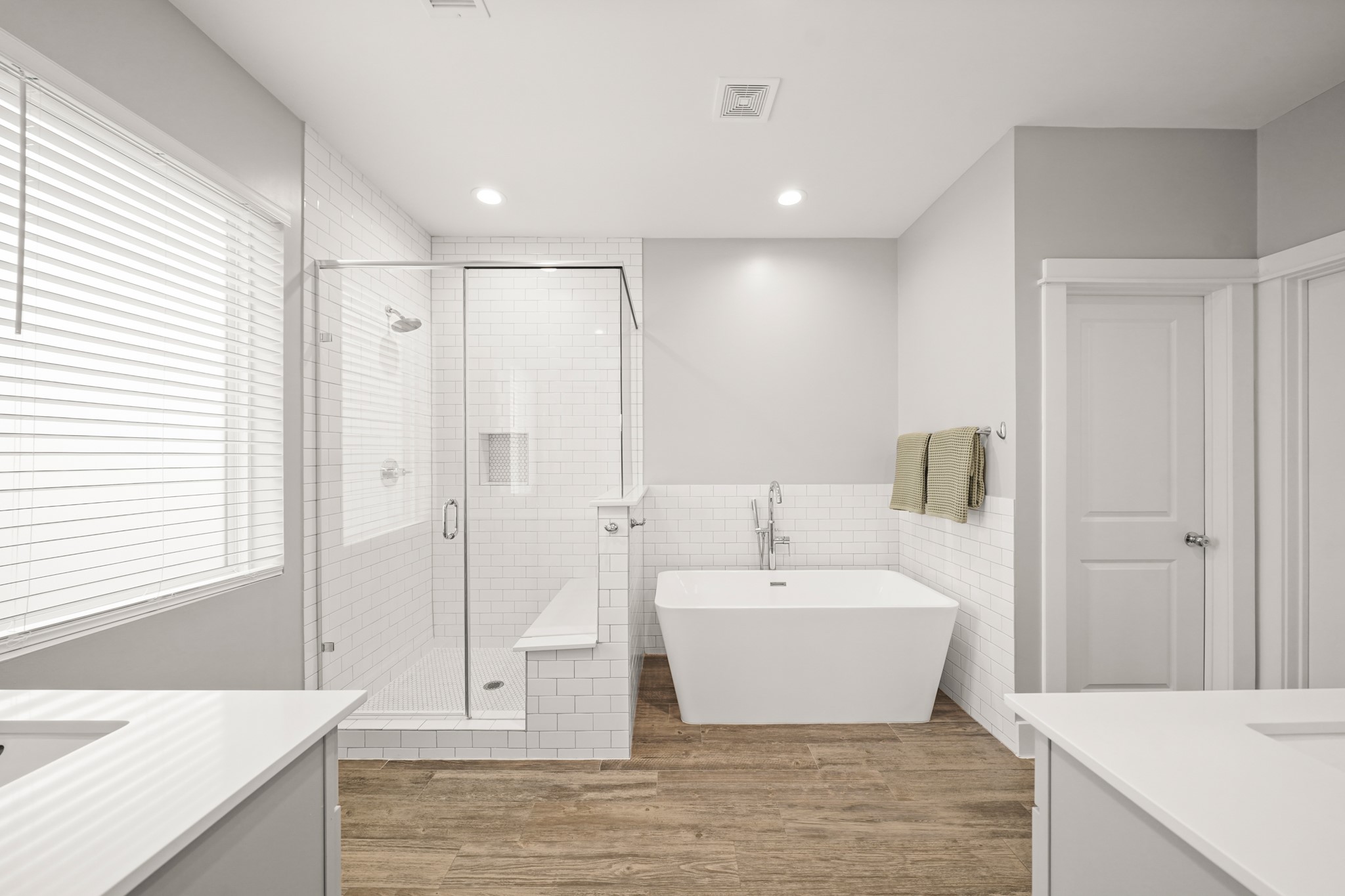 720 West Donovan Street Houston, TX 77091 - Photo 26 of 42 Relax and unwind in the primary bath featuring a free-standing soaking tub with floor mounted polished chrome plumbing fixtures surrounded by tiled accent walls and nearby floor-to-ceiling tile surrounded walk-in shower with frameless glass enclosure.