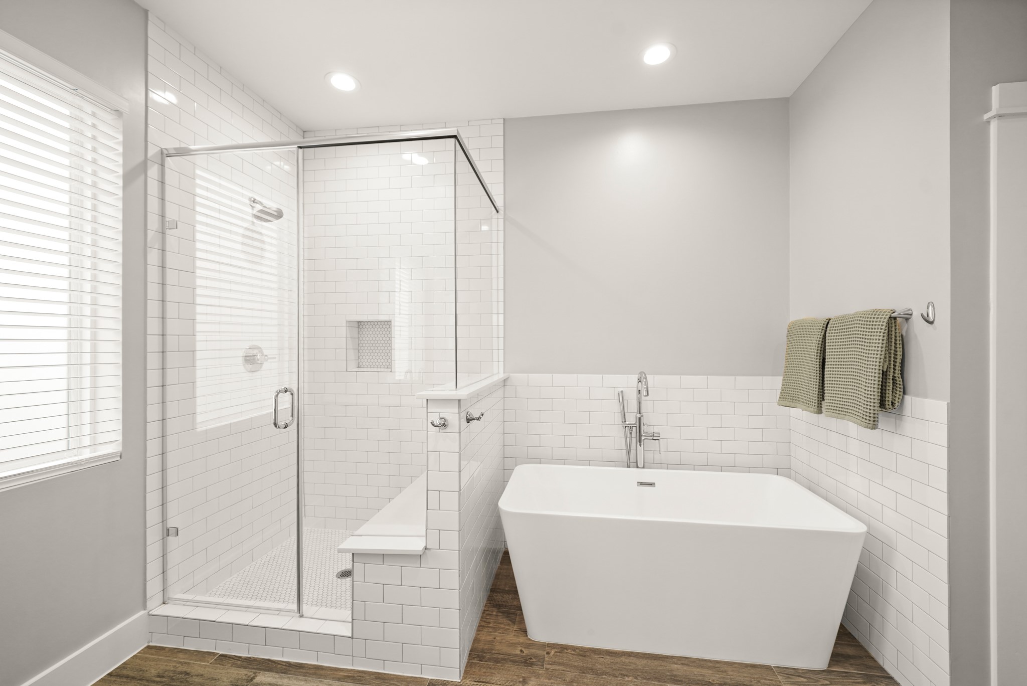 720 West Donovan Street Houston, TX 77091 - Photo 27 of 42 Natural light pours in through the fixed window onto the glass-enclosed shower lined with white subway tiles, complete with a recessed niche for shampoo/soap and a built-in bench for added comfort.