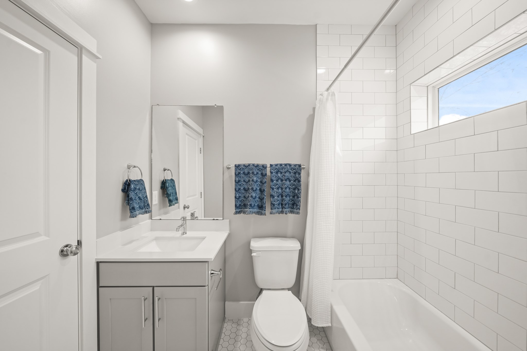 720 West Donovan Street Houston, TX 77091 - Photo 30 of 42 The ensuite bath includes recessed lighting, painted Shaker-style cabinets with quartz countertop and under-mount sink, wall mounted mirror, a subway tile surrounded combination tub/shower with fixed glass window above and hexagonal tile flooring.