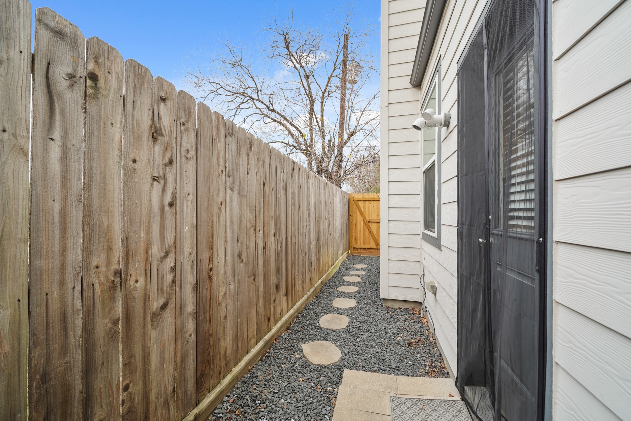 720 West Donovan Street Houston, TX 77091 - Photo 35 of 42 No other home in the community has a side yard which is fully enclosed by a wood fence replaced in 2025. Adjacent to the dog park, the gravel path and stone walkway creates an easy, low-maintenance transition to the outdoor space. It’s a clean, private area designed for various uses.