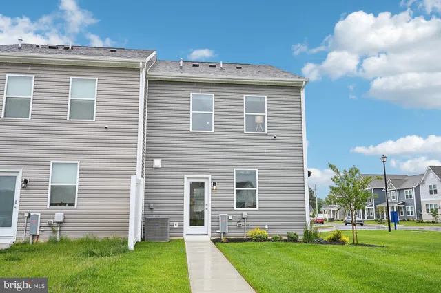 a view of a house with a yard and a large tree