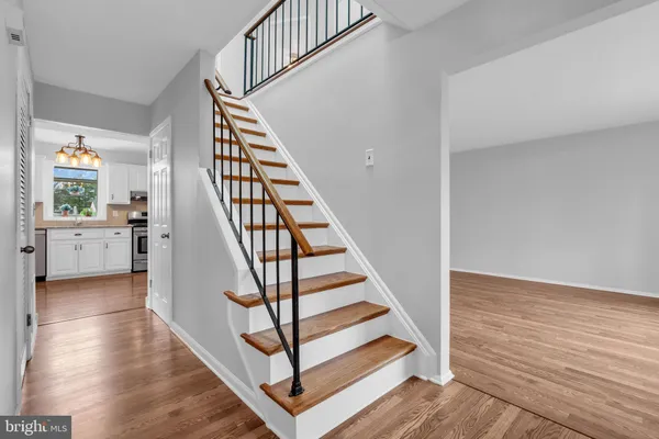 a view of a hallway with wooden floor and staircase