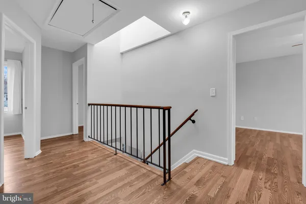 a view of a hallway with wooden floor and stairs