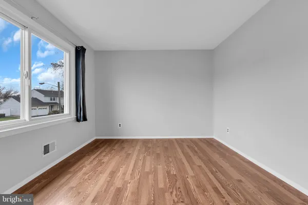 a view of a room with wooden floor and a window