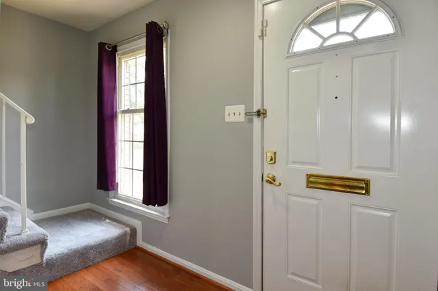 a view of a hallway with wooden floor and entryway