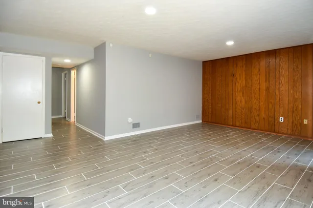 a view of an empty room with glass door and a window