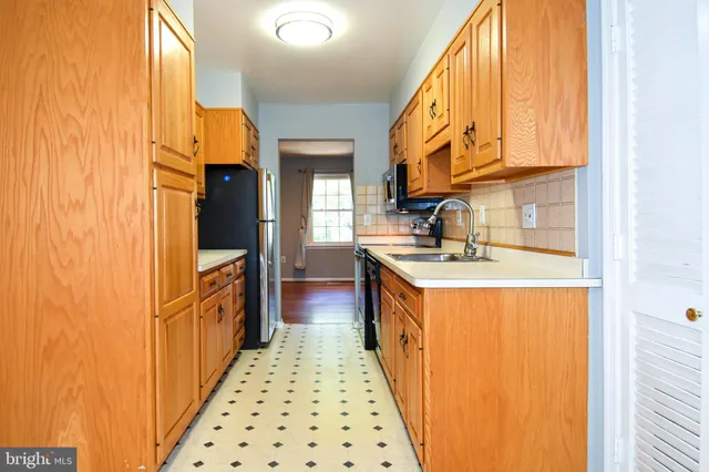 a kitchen with stainless steel appliances granite countertop a sink a stove and cabinets