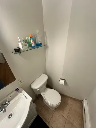 a bathroom with a toilet a sink and mirror