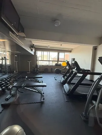 a gym room with gym equipment and a large window