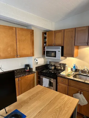 a kitchen with a stove a sink a microwave a dining table and chairs