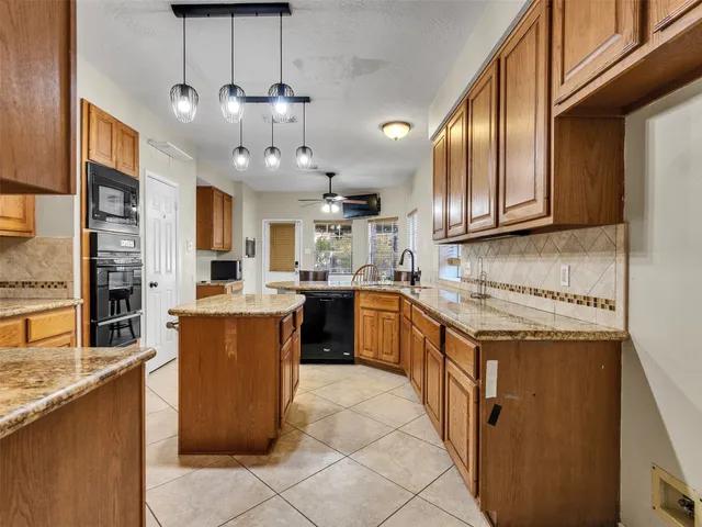 a kitchen with stainless steel appliances granite countertop a stove a sink dishwasher and a refrigerator