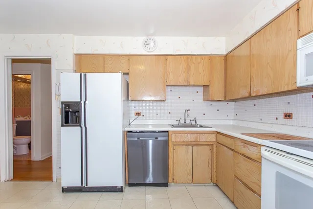 a kitchen with a sink a refrigerator and cabinets
