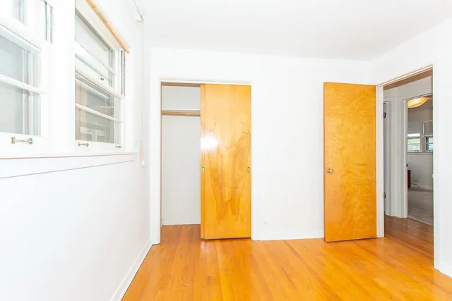 a view of a room with wooden floor and a bathroom