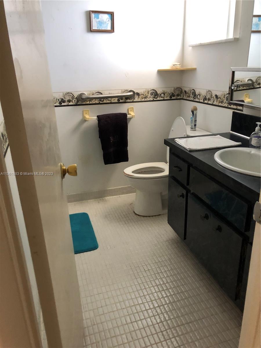 Royal Oaks Miami, FL 33179 - Photo 8 of 18 a bathroom with a granite countertop sink and a toilet