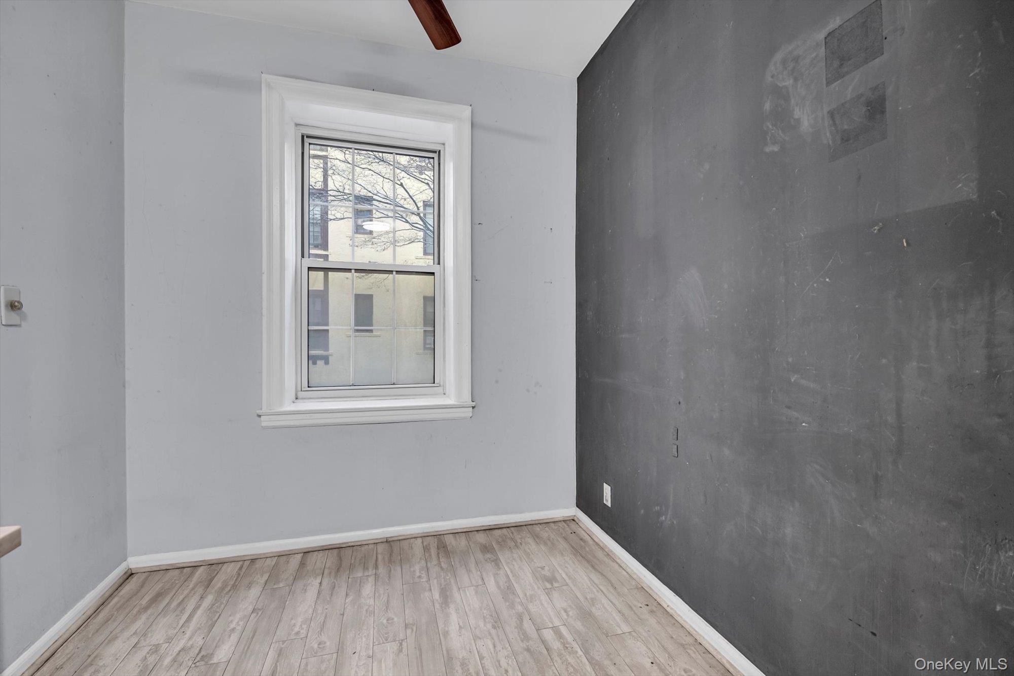 4 Maple Drive, Unit 1J Great Neck, NY 11021 - Photo 11 of 15 a view of an empty room with wooden floor and a window