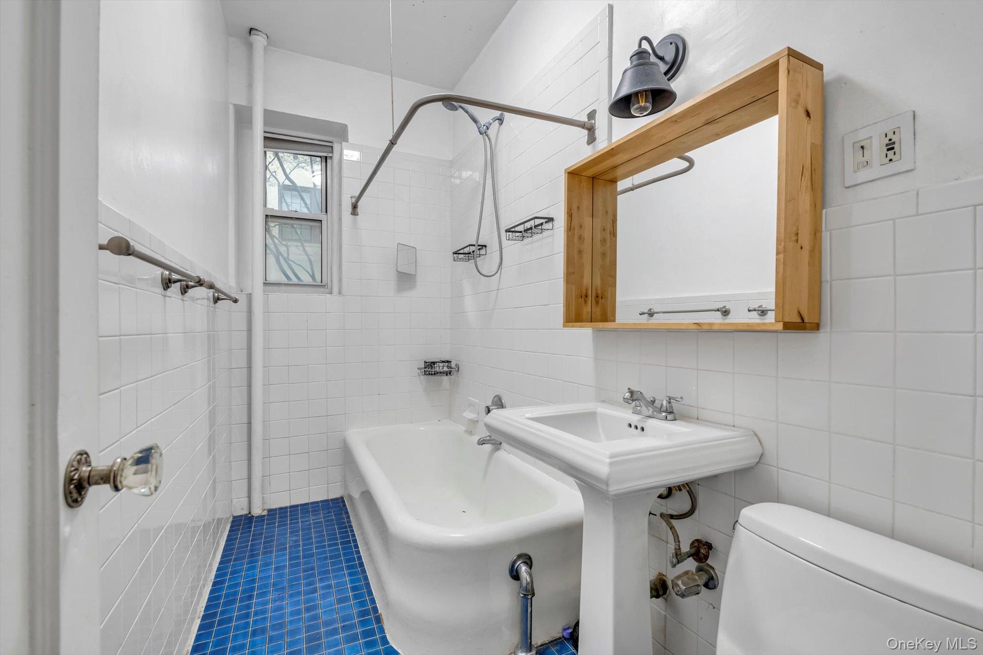 4 Maple Drive, Unit 1J Great Neck, NY 11021 - Photo 12 of 15 a bathroom with a sink and mirror with toilet