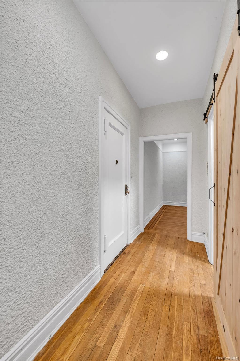 4 Maple Drive, Unit 1J Great Neck, NY 11021 - Photo 5 of 15 a view of empty room with wooden floor