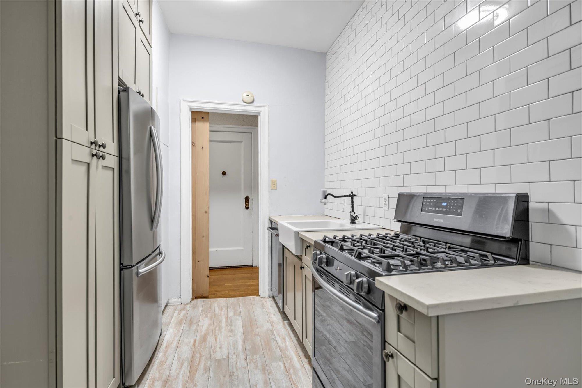 4 Maple Drive, Unit 1J Great Neck, NY 11021 - Photo 8 of 15 a kitchen that has a stove and a wooden floor