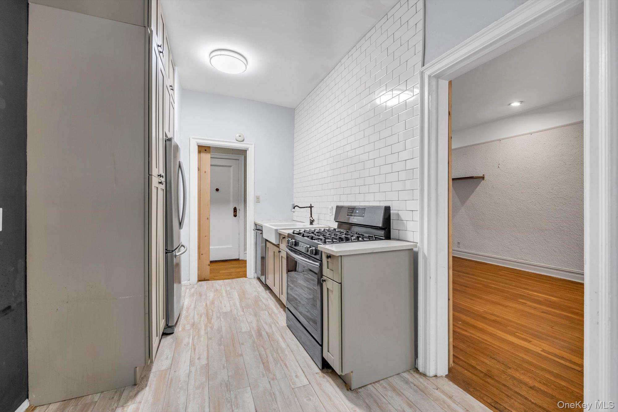 4 Maple Drive, Unit 1J Great Neck, NY 11021 - Photo 9 of 15 a kitchen with a stove and a refrigerator