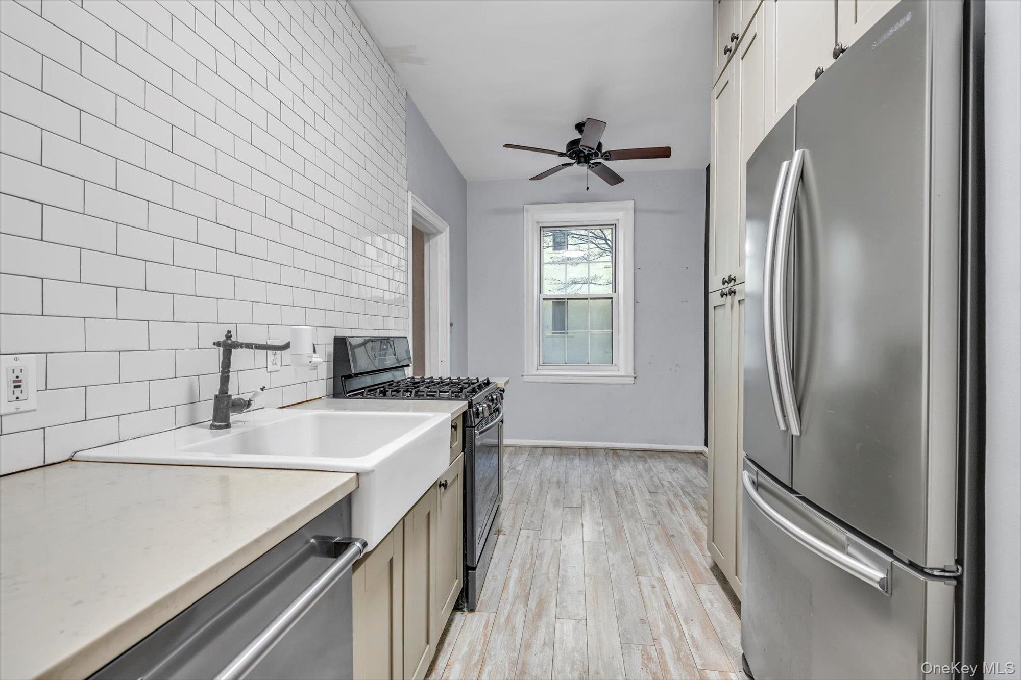 4 Maple Drive, Unit 1J Great Neck, NY 11021 - Photo 10 of 15 a kitchen with stainless steel appliances granite countertop a sink stove and refrigerator
