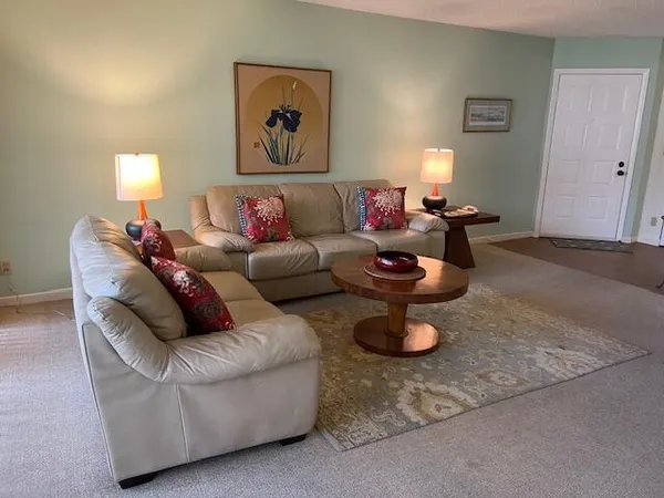 a living room with furniture a rug and lamp