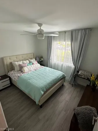 a bedroom with a bed mirror and window