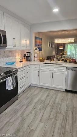 a kitchen with granite countertop a stove a sink and a granite countertops with cabinets