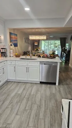 a kitchen with wooden floors and white cabinets