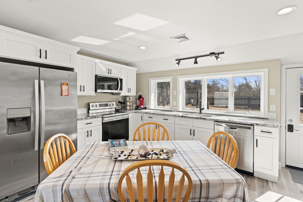 278 A Delano Road Marion, MA 02738 - Photo 7 of 32 a kitchen with stainless steel appliances granite countertop a stove a sink a dining table and chairs