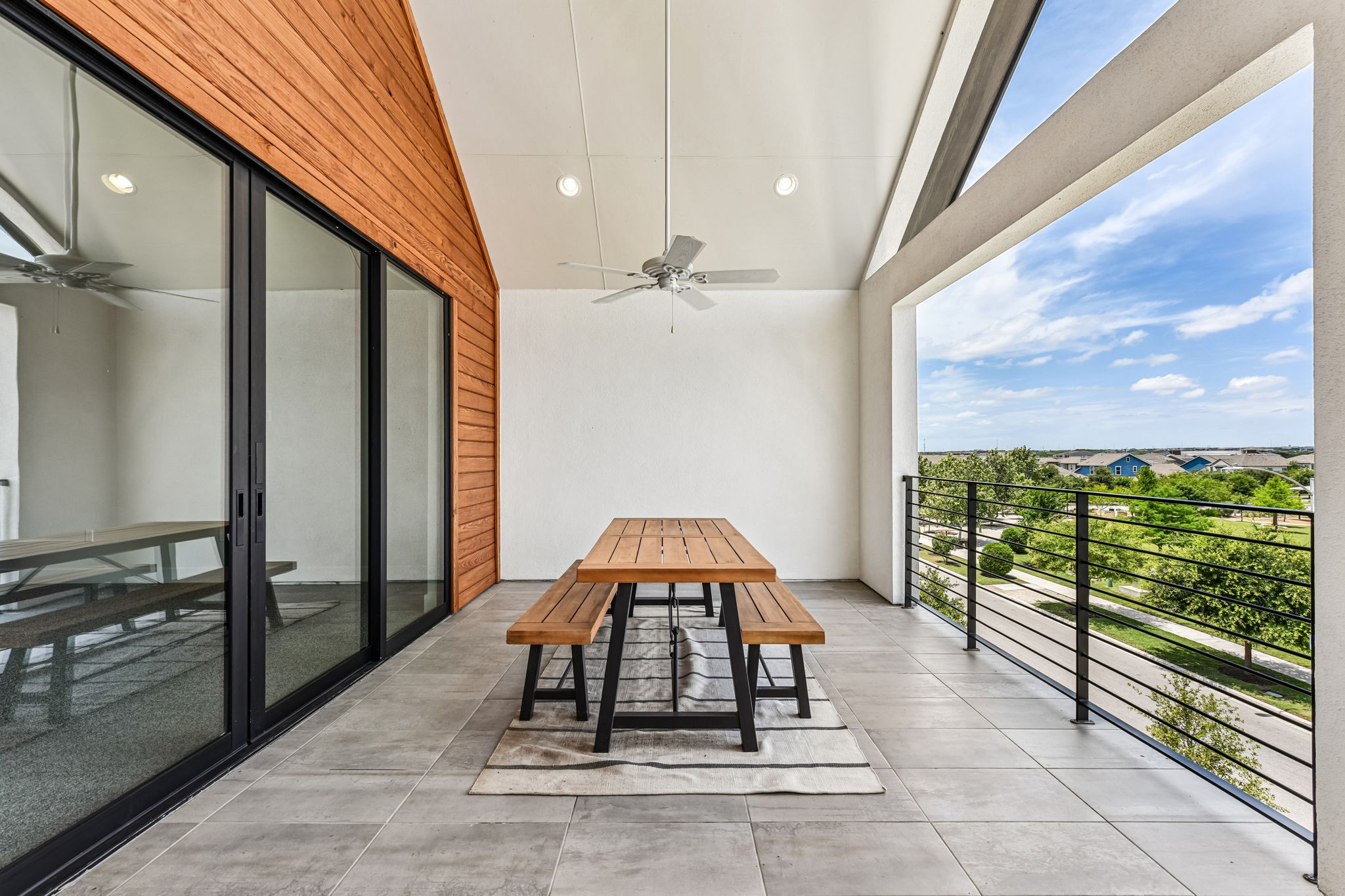 9033 Cattle Baron Path Austin, TX 78747 - Photo 38 of 40 An inviting covered balcony features wood paneling and sleek tile flooring, offering elevated neighborhood views.