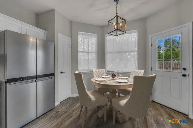a dining room with furniture a chandelier and wooden floor