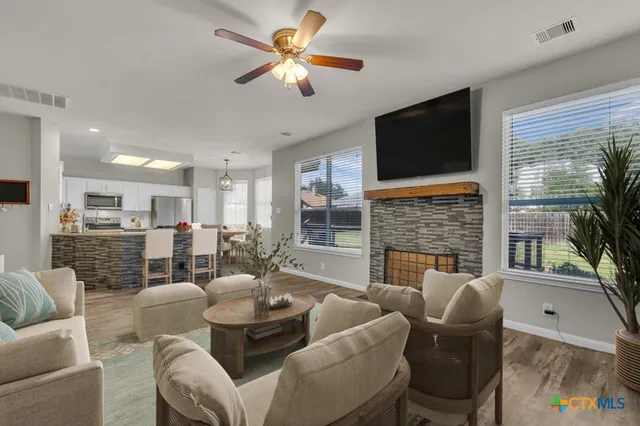 a dining room with furniture a fireplace and a flat screen tv