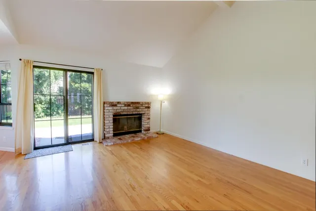 a view of an empty room with a fireplace and a window