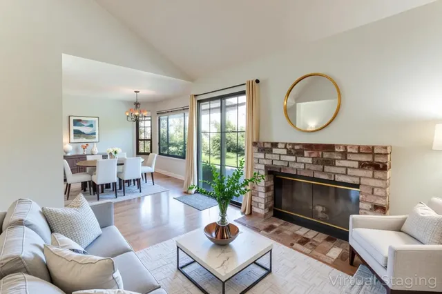 a living room with furniture a fireplace a window and a large window