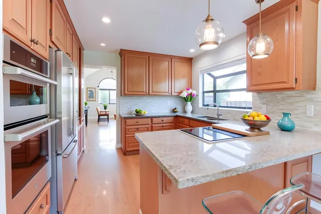 a kitchen with stainless steel appliances granite countertop a sink a stove counter space and cabinets