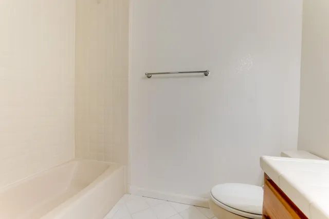 a white toilet sitting next to a bath tub