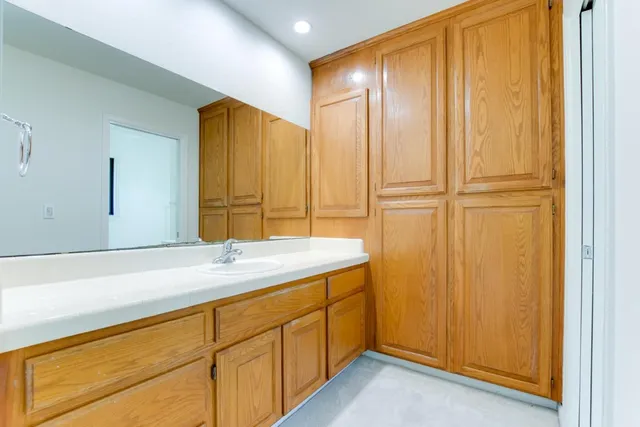a bathroom with a granite countertop sink and a mirror
