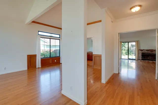 a view of a hallway with wooden floor and a table