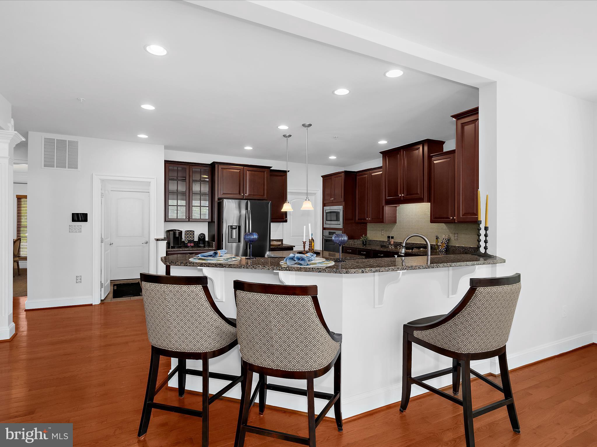13801 Racetrack Field Court Bowie, MD 20720 - Photo 25 of 66 a kitchen with stainless steel appliances a dining table chairs microwave and sink