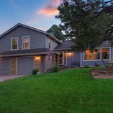 a front view of a house with a yard and trees