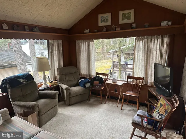 a living room with furniture a dining table and a bookshelf